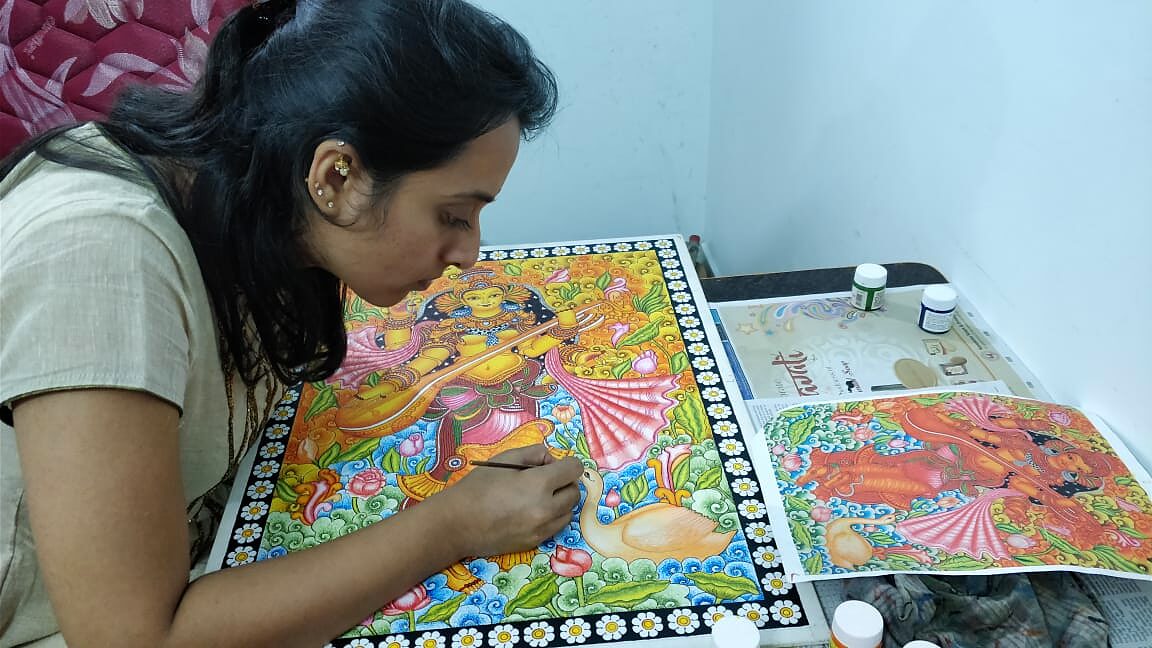 Student painting a Saraswati Kerala Mural